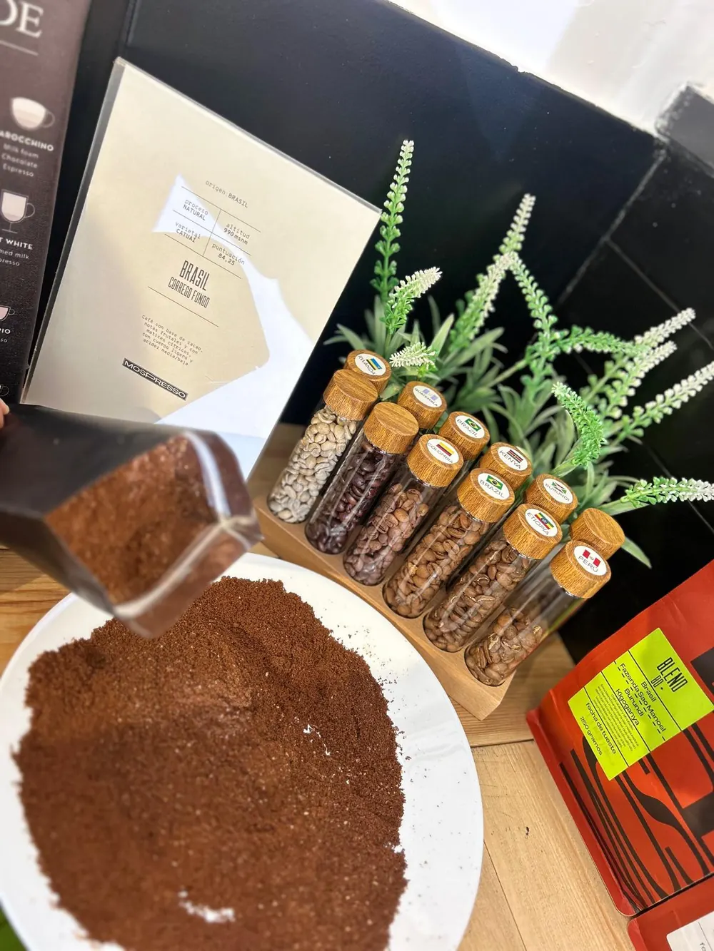 Café recién molido sobre un plato, junto a un expositor de muestras