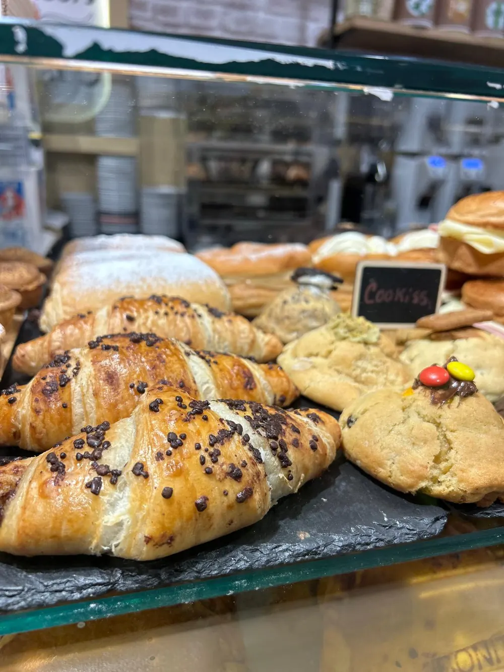 Croissants y pastas recién hechos sobre pizarra en la vitrina